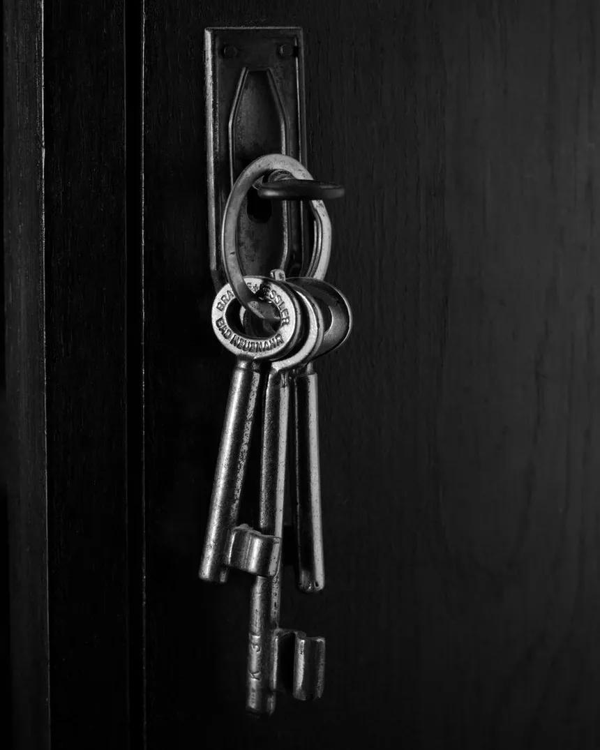 Un trousseau de clés suspendu à une porte sombre.